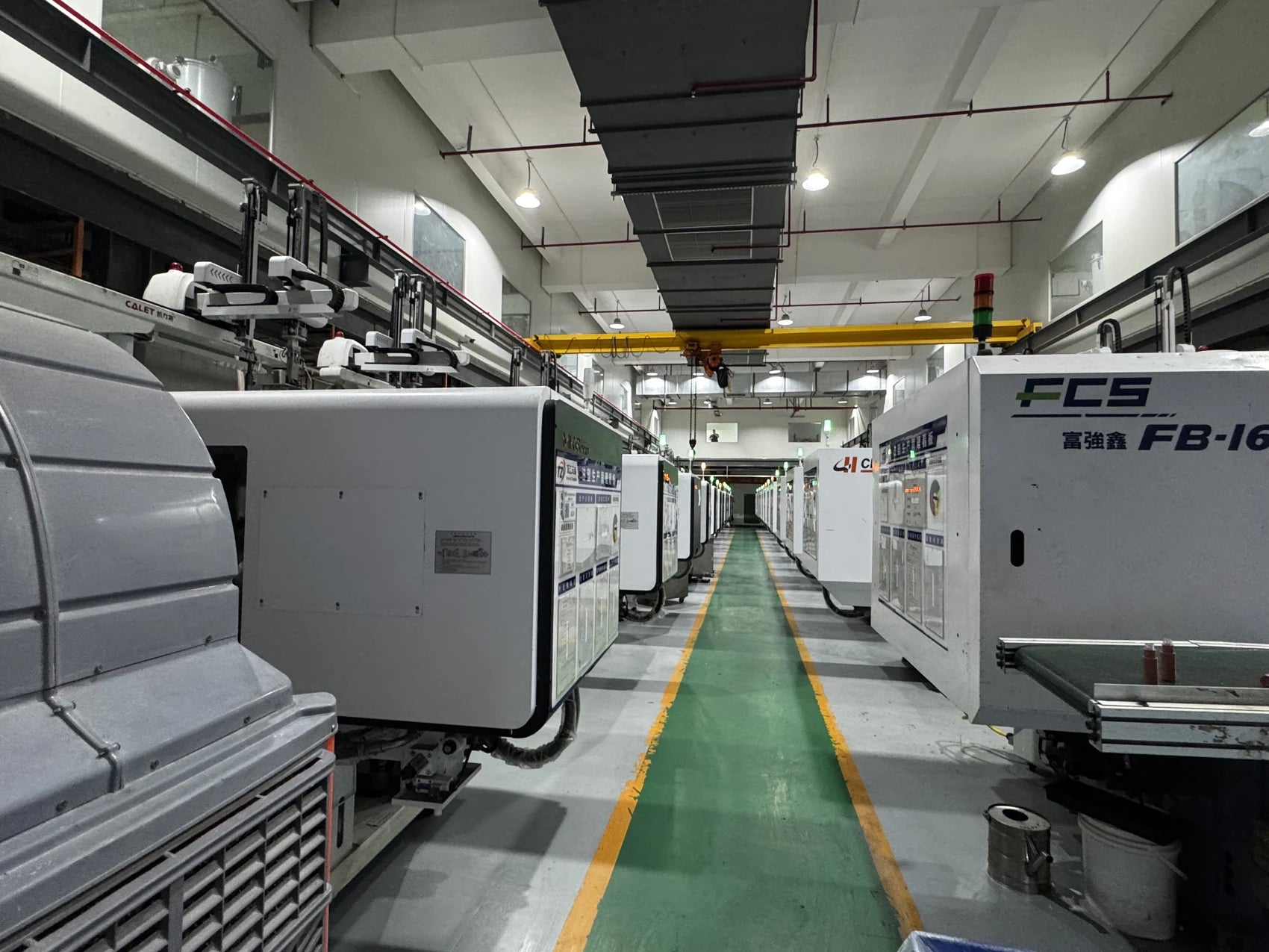 Injection molding equipment arranged along the factory aisle